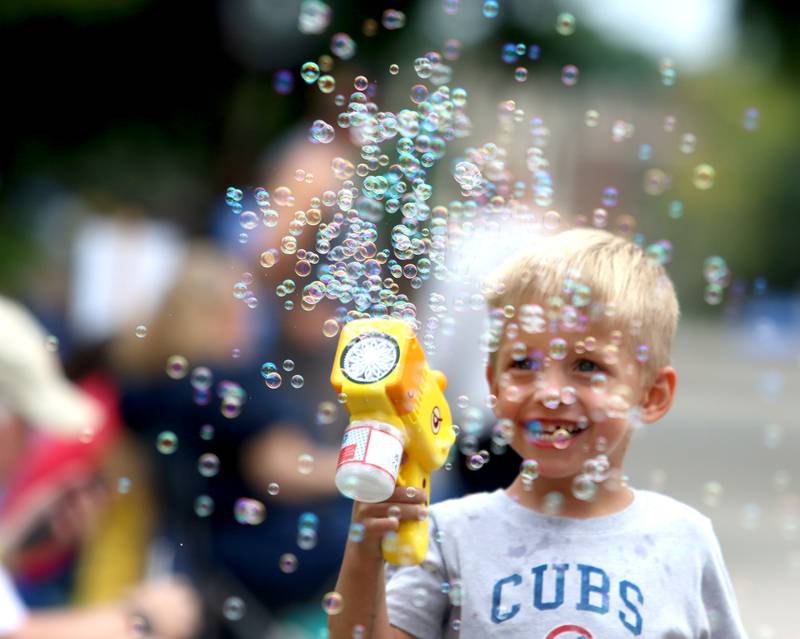 Charlie Rogers, 3, of Chicago makes bubbles as he waits for the Fiesta Days Parade to begin down Main Street in McHenry on Sunday, July 20, 2025. Rogers was in attendance at the parade with his grandparents who are from Woodstock.