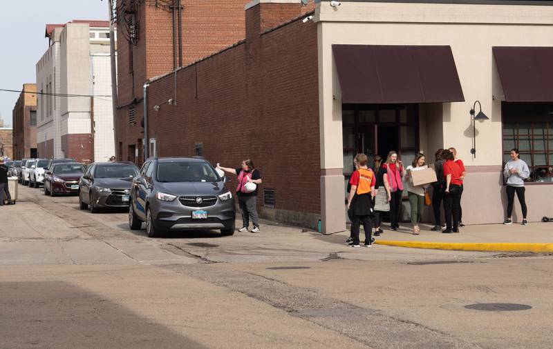 Volunteers help distribute dinners to cars during the Lighted Way Spaghetti Supper on Monday, April 22, 2024 at Uptown Bar and Grill in La Salle.