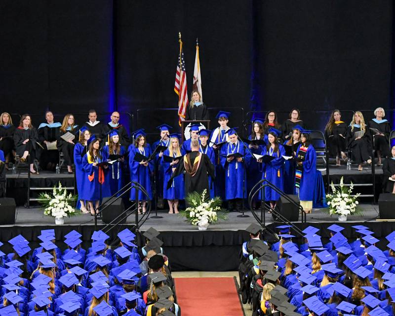 Senior members of the St. Charles North choir sings on Monday, May 18, 2026, during the graduation ceremony held at the NIU Convocation Center in DeKalb.