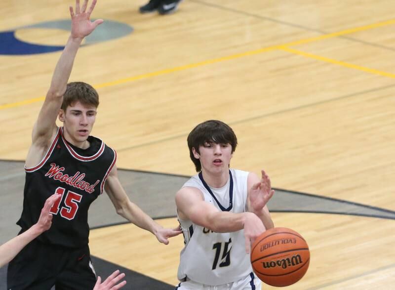 Marquette's Alec Novotney passes the ball while being guarded by Woodland's Quintin Porter during the Tri-County Conference Tournament on Thursday, Jan. 25, 2024 at Putnam County High School.
