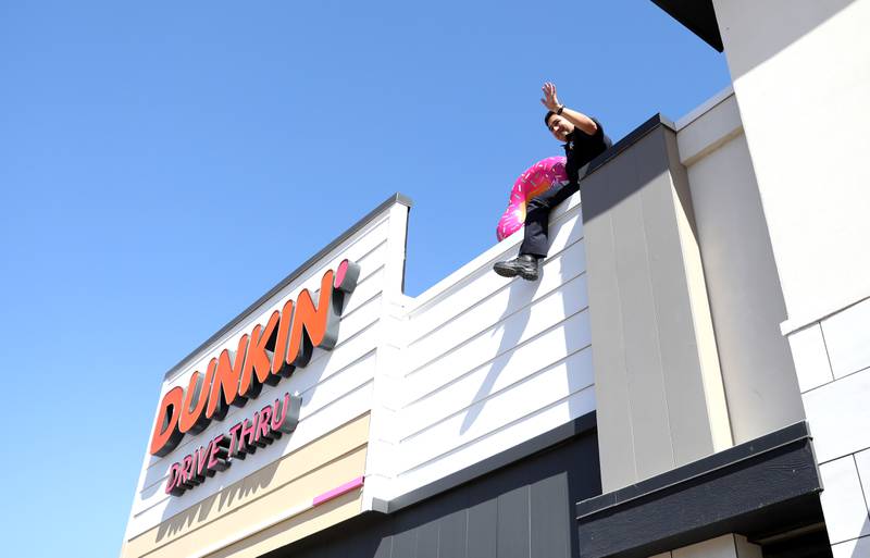 St. Charles Police Officer Chris Morales sits on top of the Dunkin’ Donuts on East Main Street in St. Charles on Friday, May 16. 2025 for the Cop on a Rooftop fundraiser for Special Olympics Illinois.