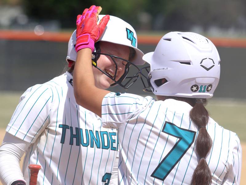 Woodstock North’s Aly Jordan, let, is greeted by Hailey Campos at home after scoring against Crystal Lake Central in IHSA Class 3A Regional Title Game softball action on Saturday, May 23, 2026 at Crystal Lake Central High School in Crystal Lake.