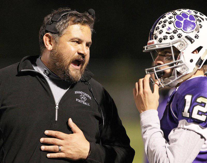 Hampshire coach Mike Brasile talks with quarterback Jake Vincent on the sideline in the first half against McHenry on Oct. 14, 2016, in Hampshire. Brasile, a 1999 Woodstock grad, was named Woodstock's head coach Tuesday evening.