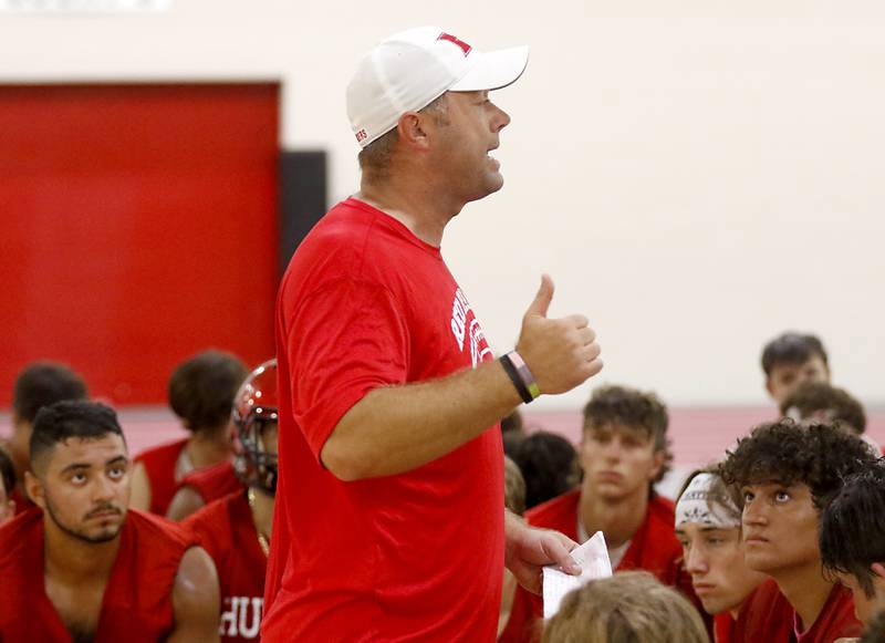 Huntley’s new coach Mike Naymola speaks to the team during the first day of football practice Monday, 8, 2022, in the Huntley High School  field house after stormy weather move practice inside.