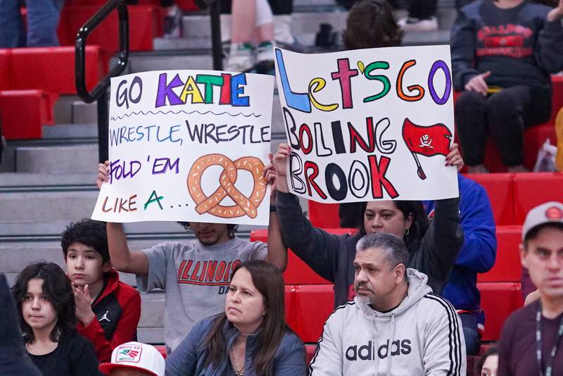 Fan’s hold up signs cheering on Bolingbrook’s Katie Ramirez-Quinter prior to the start of her 135 pound match against Elmwood Park’s Rose Craig in the Schaumburg Girls Wrestling Sectional at Schaumburg High School on Saturday, Feb 10, 2024.