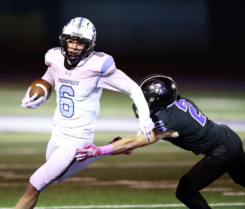 Prospect's Nathan Cichy (6) slides around Downers Grove North's Shawn Toth (2) during the IHSA Class 7A playoff football game Friday, Oct. 31, 2025 in Downers Grove.