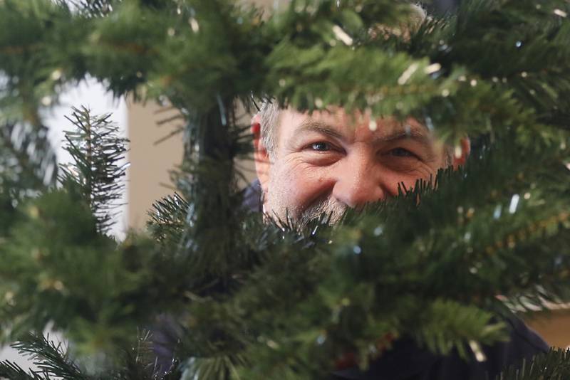 Scott Giles peers through tree branches as he installs lights on the Fantasy Factory Christmas trees on Thursday, Nov. 16, 2023, as he prepares the tree for the McHenry Chamber of Commerce Festival of Trees at the McHenry Recreation Center. The tree festival runs through Dec. 30, You can vote for your favorite Christmas tree by leaving canned food or toiletries under the tree you like best during normal business hours. All donations go to Veteran’s Path to Hope.