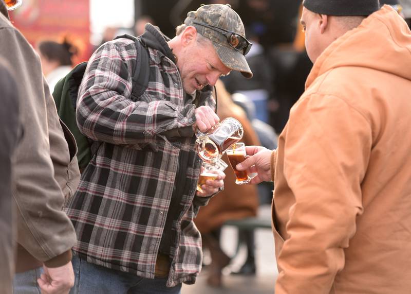 Tj Strouse of Braidwood shares a beer with Rocco Trentadue of Lombard during the Winter Beer Festival held in Westmont Saturday Feb 18, 2023.