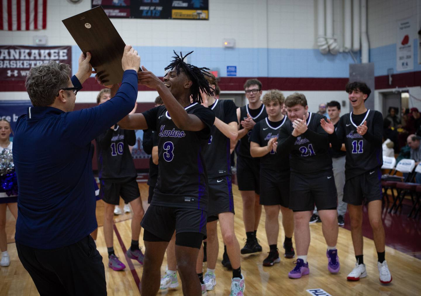 Manteno's Ray Lee receives the championship plaque (blue division) from Bill Yohnka, left, after defeating Joliet Catholic Academy in Saturday's Kankakee Holiday Tournament.