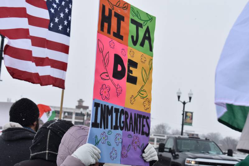 A woman holds up a sign which translates to “daughter of immigrants” at the protest Saturday, Feb. 15, 2025, on First Avenue bridge between Sterling and Rock Falls.