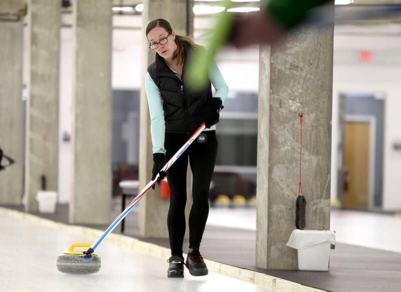 Rachel Ault of Westmont directs the stone on the ice sheet during a drop-in game of Curling at the Windy City Curling Club in Villa Park.