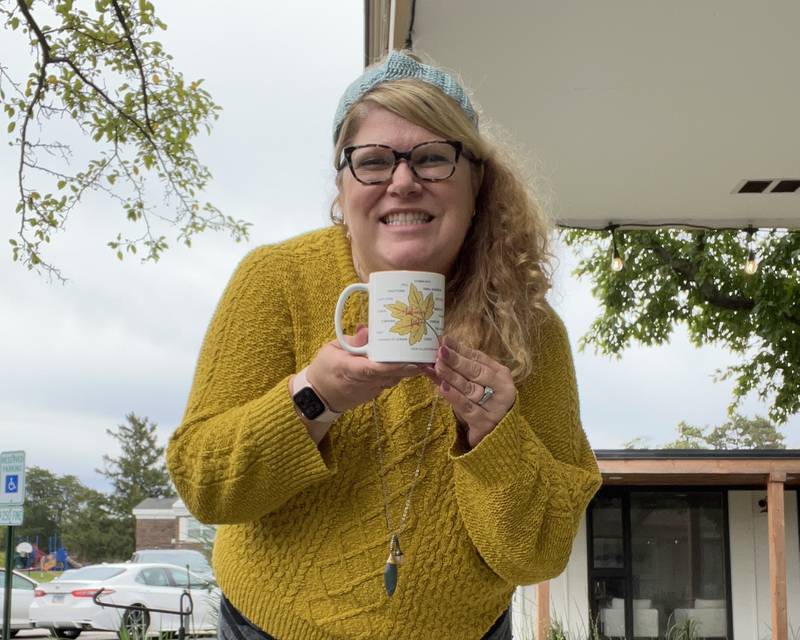 Kristen Cornelio of Kristen Holly holding the special event mug created by Image Awards, Engraving & Creative Keepsakes owner Patty Donahue for the fourth annual Jack-o’-lantern walk Oct. 7 in downtown Geneva.