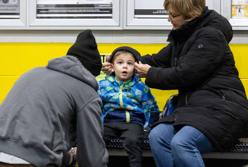 Laura Sharkey puts a hat on her grandson Colton Sharkey, 3, while his dad Ryan Sharkey takes off his skates during open skate at Crystal Ice House in Crystal Lake on Friday, Jan. 3, 2025.
