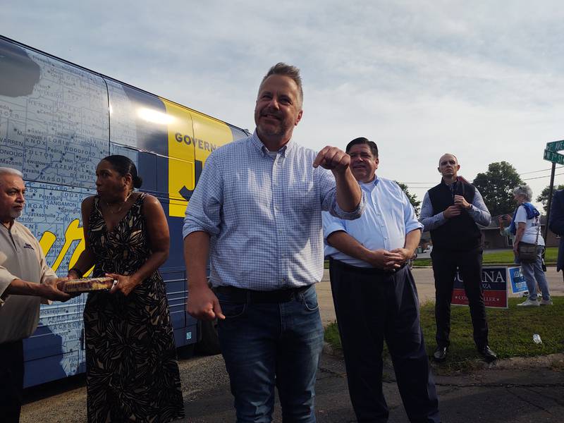 Lt. Gov. Juliana Stratton accepts a coffee cake for road while candidate for Congress Eric Sorensen makes his stump speech while Gov. JB Pritzker listens during a campaign stop Sunday morning at the Whiteside County Democratic Headquarters in Rock Falls.