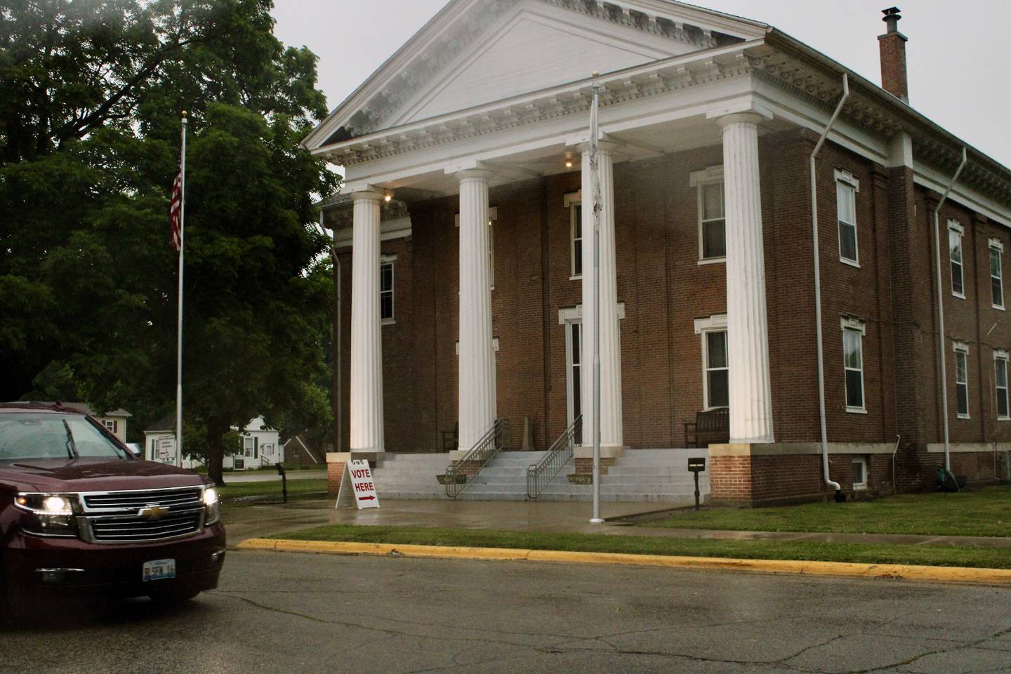 Vehicles run with headlamps while lights flare on the steps of the Putnam County Courthouse amid darkened skies from thunderstorms Saturday morning in Hennepin.