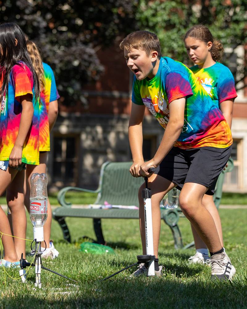 Griffin screams “fire in the whole” as he fires a two liter bottle rocket during the 23rd annual Carus Summer Science Camp on Friday, July 18, 2025 at St. Bede High School in Peru.