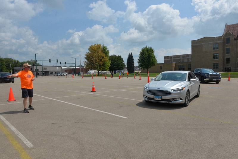 Dixon Kiwanian Chris Hammitt directs a car to the distribution tent on Thursday, Aug. 10, 2023.