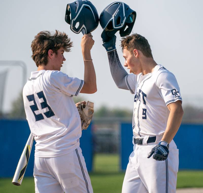 Oswego East's Zachary Polubinski (9) is greeted by Oswego East's Mason Blanco (23) after homering against Oswego during a baseball game at Oswego East High School on Tuesday, May 10, 2022.