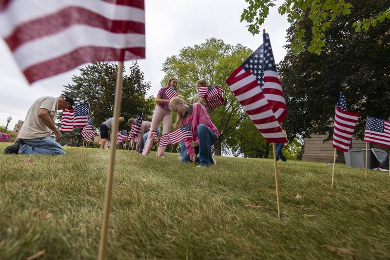 Hunter Roe, 14, plants one of 2,977 flags, each in remembrance of a victim on 9/11, on the lawn of the Old Lee County Courthouse in Dixon Wednesday, Sept. 6, 2023. The group was working with the Young America’s Foundation who sponsored the event.