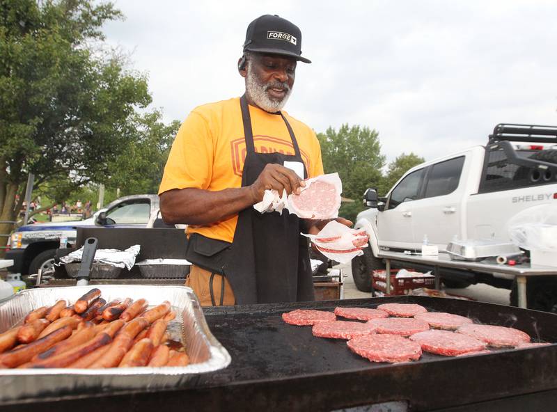 Chris Smith, of Zion with the Brat Shop, makes hotdogs and hamburgers during the final concert of the "It’s Thursday” summer concert series on August 10th in Antioch. The event and its proceeds were dedicated to Huntley, a child who was injured during the Taste of Summer in July. 
Photo by Candace H. Johnson for Shaw Local News Network