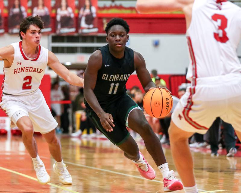 Glenbard West's Teyion Oriental (11) drives around the defense during their basketball game between Glenbard West at Hinsdale Central, Friday  Dec 6, 2024  in Hinsdale.