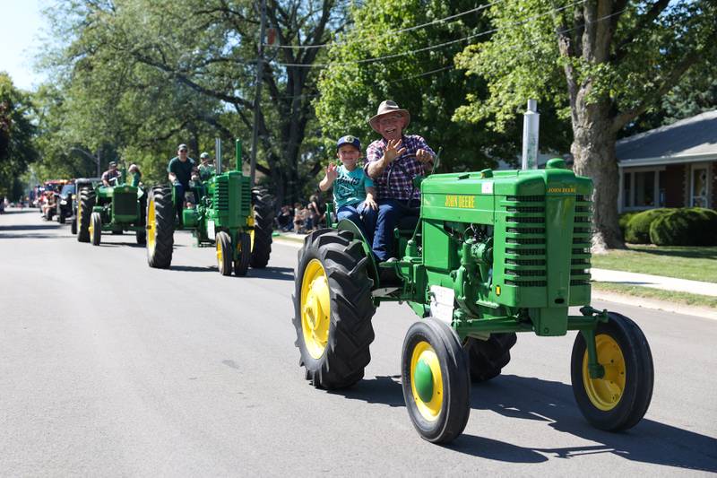 Parade participants wave from atop an antique tractor during the 104th annual Herscher Labor Day Celebration Grand Parade on Monday, Sept. 1, 2025.