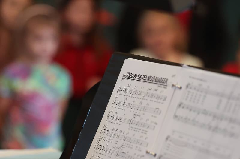 Sheet music for Rudolph the Red-Nosed Reindeer sits on the piano at the children’s choir rehearsal at the Cathedral of Saint Raymond Nonnatus for the upcoming A Very Rialto Christmas show.