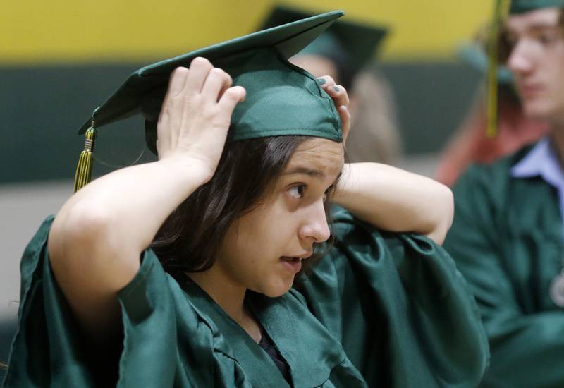 Reese Becker fixes her cap as she waits Saturday, May 13, 2023, for the graduation ceremony for class of 2023 to begin at Crystal Lake South High School in Crystal Lake.