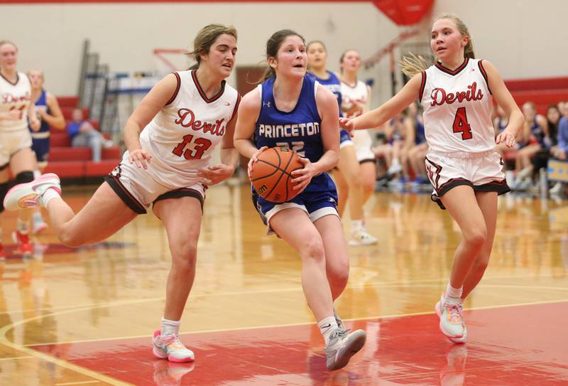 Princeton's Camryn Driscoll runs in the lane to eye up the hoop as Hall's Mckenna Christiansen and teammate Charlie Pellegrini defend on Thursday, Nov. 30, 2023 at Hall High School.