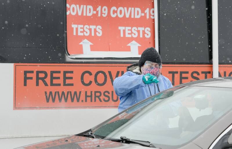 IDPH (Illinois Department Public Health) contractor Josie Alfaro of Rockford instructs people on how to self administer the COVID-19 test at the mobile pop-up testing site at DeKalb High School on Saturday, Feb. 13, 2021 in DeKalb.