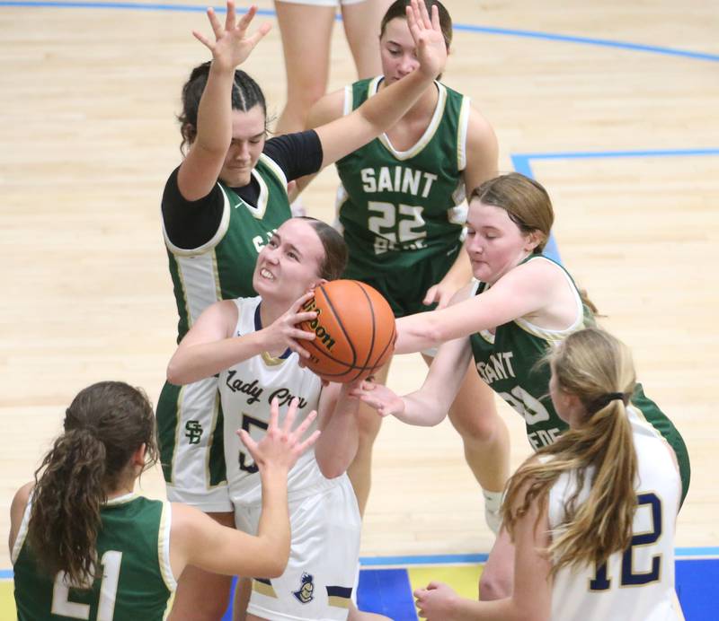 Marquette's Chloe Larson fights her way through the lane as St. Bede's Ali Bosnich, Ella Hermes and Lili McClain defend on Monday, Nov. 27, 2023 in Bader Gym at Marquette High School.