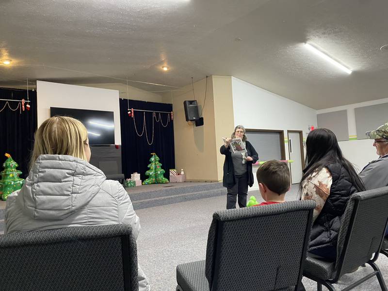 Pam Burton from the Morris Area Public Library entertains a group of children with her reading of "Merry Christmas, Splat," a story about a cat who is trying really hard to show Santa they've been good before Christmas.