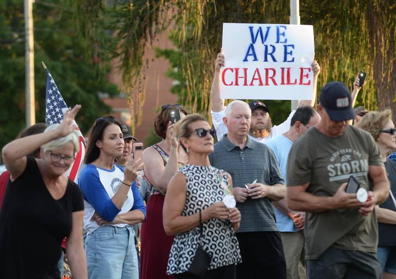 Some people who attended a vigil for Charlie Kirk on Sunday, Sept. 14, 2025 in Oregon held signs during the hour-long event.