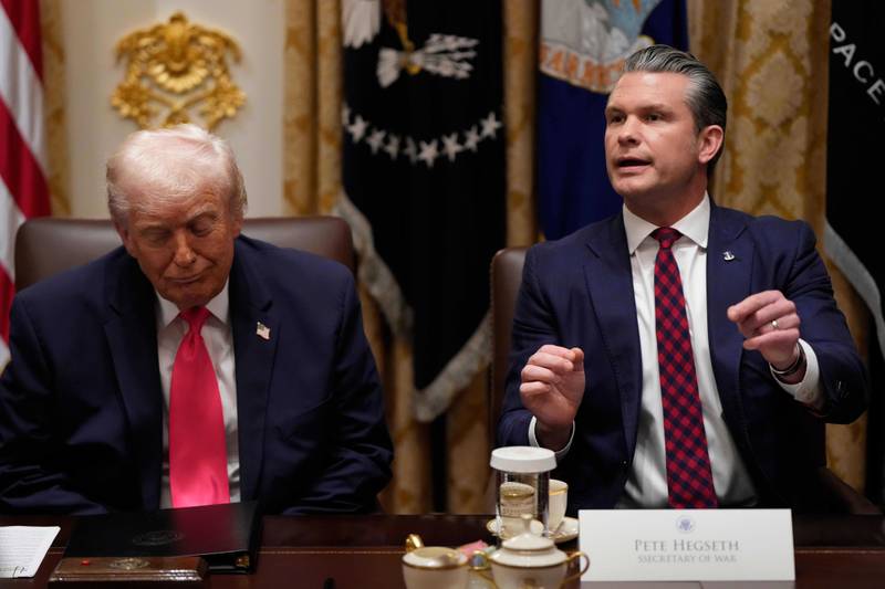 Defense Secretary Pete Hegseth speaks as President Donald Trump looks on, during a Cabinet meeting at the White House, Tuesday, Dec. 2, 2025, in Washington. (AP Photo/Julia Demaree Nikhinson)
