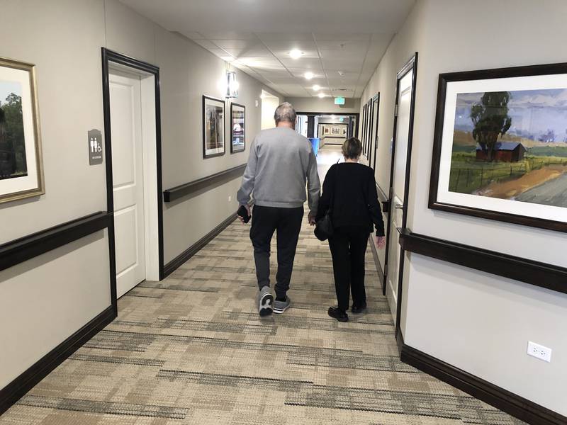 Charlie, 79, and Linda Farley, 75, hold hands as they walk through Cedarhurst of McHenry on Thursday, Feb. 23, 2022. The couple are among the first residents of the new assisted living facility.