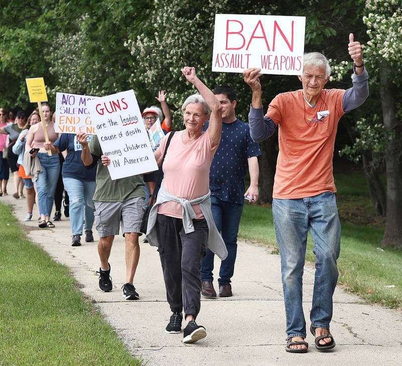 Protesters marching north on Sycamore Road in DeKalb acknowledge the honking cars Saturday, June 11, 2022, during a March For Our Lives event which kicked off at Hopkins Park in DeKalb. The March For Our Lives initiative advocates for, among other things, an end to gun violence, updated gun control legislation and policy targeting gun lobbyists.