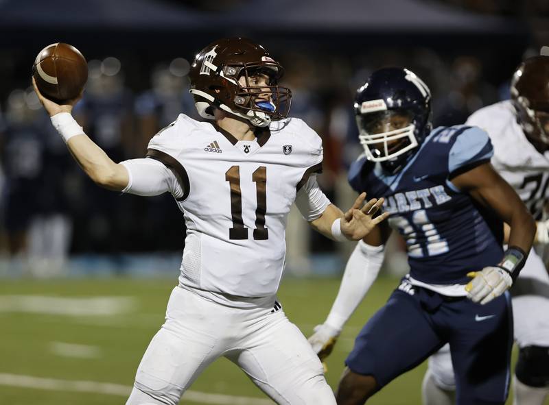 Joliet Catholic's Lucas Simulick (11) looks for a receiver during the varsity football game between Joliet Catholic and Nazareth academies on Friday, Sep. 27, 2024 in La Grange Park.
