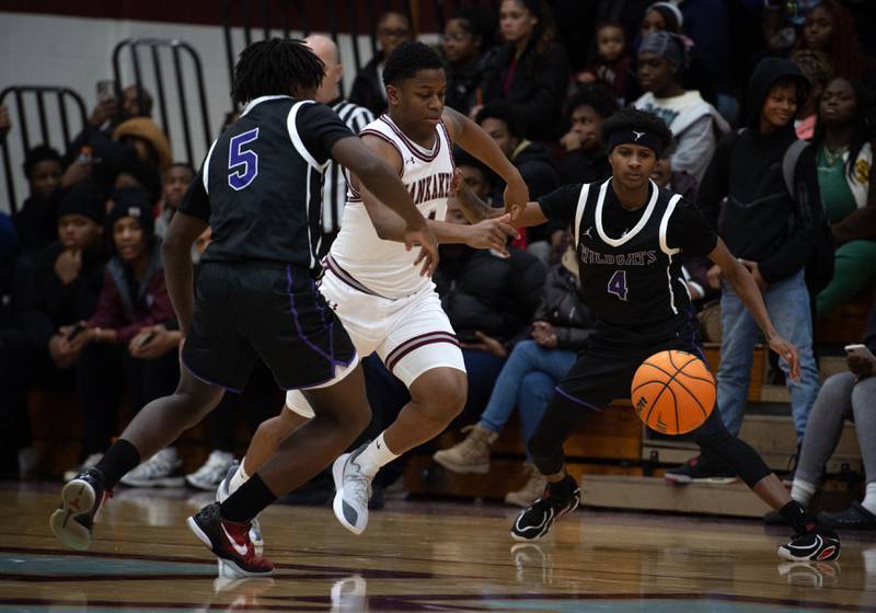 Kankakee's Myair Thompson, center, looks to recover a loose ball from Thornton's DaKari Nesbitt, left, and Anthony Fourte, right, in a game on Friday, December 12, 2025.