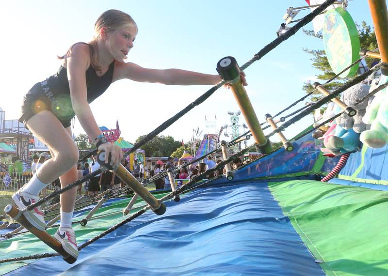 Lala Kostellic of Oglesby, climbs a jungle ladder during the Summer Fun Fest on Friday, June 14, 2024 in Oglesby.