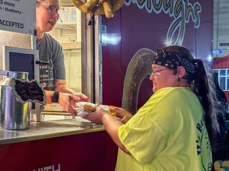 Woman purchases a pretzel from Didoughs on Saturday, October 5, 2024 at Rotary Park in Princeton.