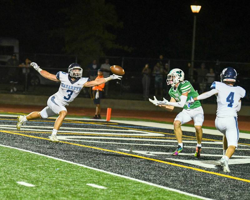 York’s Luke Mailander, center, catches the ball for a touch down while being defended by Nazareth Academy teammates Jaden Fauske (3) and Drew Fowler (4) during the second quarter during a home game in Elmhurst Friday Sep. 1, 2023.
