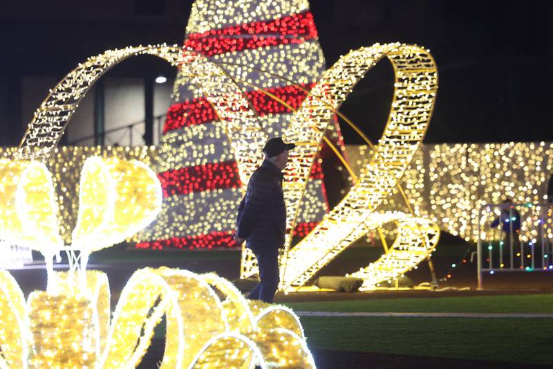 A man walks along the lights at the GLOW Holiday Festival at Slammers Stadium on Wednesday, Nov. 27, 2024 in Joliet.