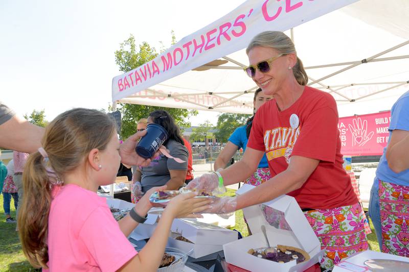 Mother’s Club member Jody Trombley hands her daughter Olivia, 7 some pie during Batavia MainStreet’s Block Party & Taste of Batavia on Sunday, Aug 31, 2025 in Batavia.