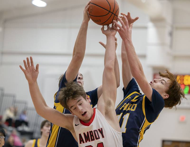 Polo’s Cayden Webster (left), Amboy’s Garrett Pertell and Polo’s Nolan Hahn go up for a rebound Wednesday, Jan. 25, 2023.