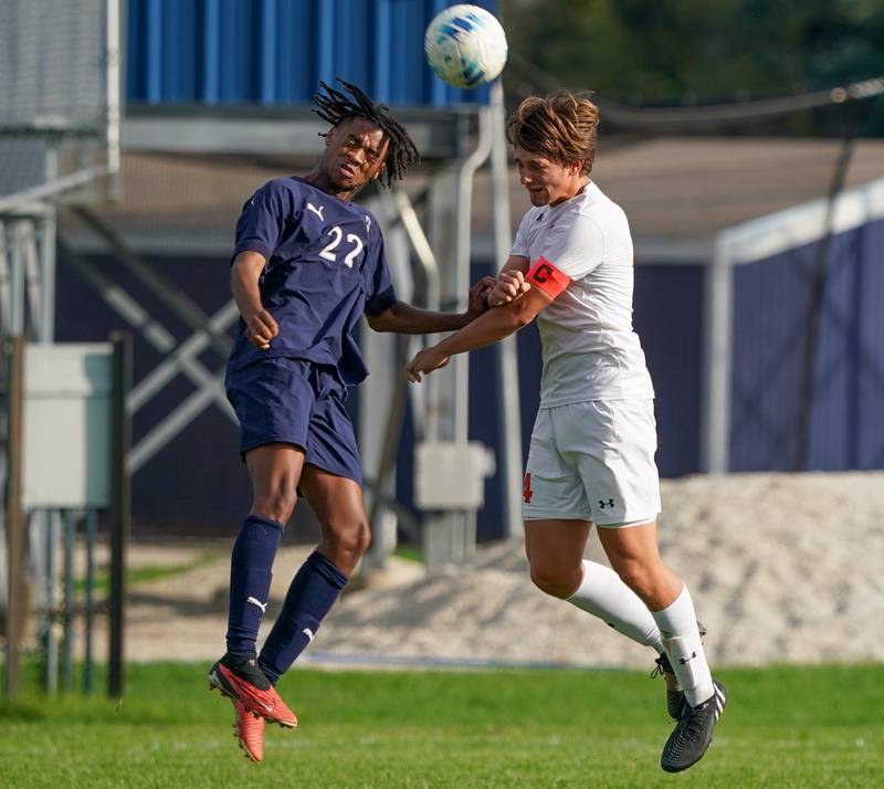 Oswego East's Marlin Hoffman (22) goes up for a header against Oswego’s Ryan Walsh (4) during a soccer match at Oswego East High School on Tuesday, Sept. 26, 2023.