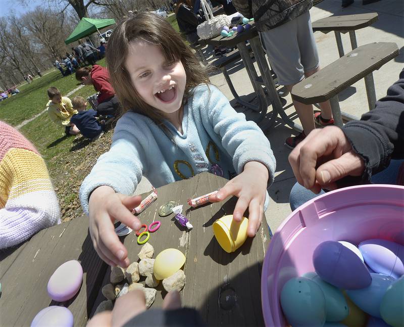 Savannah Neil, happily breaks apart the eggs she found the see what treats they contain during the annual Easter Egg Hunt Saturday sponsored by Marseilles Recreation at Illini State Park in Marseilles.