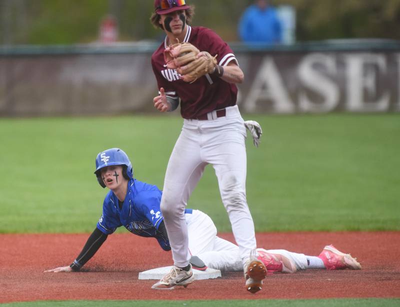 St. Francis' Zach Maduzia slides safely into second base under the watch of Wheaton Acadey's Hudson Williams (1) during Tuesday’s baseball game in West Chicago.