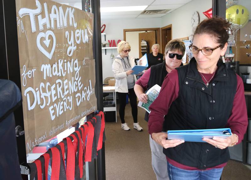 Volunteers Chris Sauter (right) and Steffanie Barringer, (second from right) both from DeKalb, pick up a Meals on Wheels delivery to distribute Tuesday, April 23, 2024, at the Voluntary Action Center in Sycamore. VAC is celebrating its 50th anniversary this year.