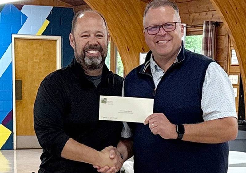 Walcamp executive director Bill Indelli accepting a spring 2025 grant check from DeKalb County Community Foundation board member Shawn Blobaum
