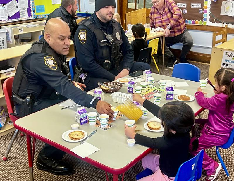 Sterling Police Department Officer Mark Mendoza gets a refill during the "Breakfast with Heroes" event at Sterling's Wallace School on Thursday, Dec. 12.
